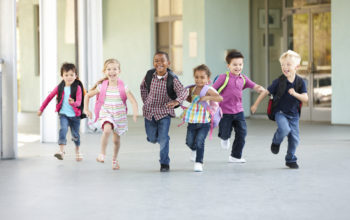 Group Of Elementary Age Schoolchildren Running Outside